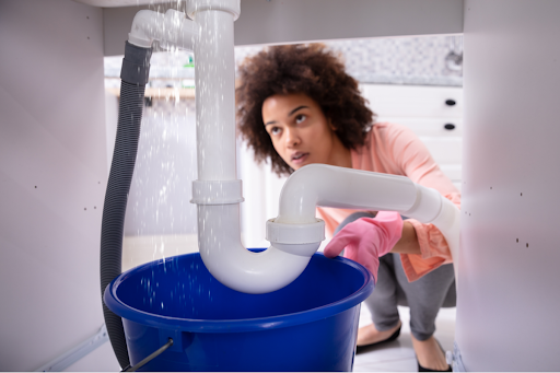 A woman checking a water leak in a Houston, TX home.